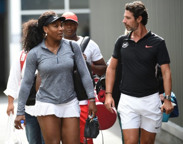 Serena Williams of the US (L) speaks with her coach Patrick Mouratoglou as she waks toward