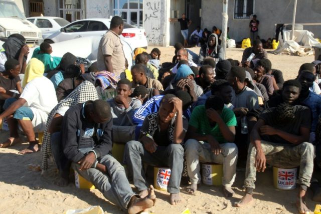 Illegal migrants sit in a port in Tagiura, east of the Libyan capital Tripoli, after 137 m
