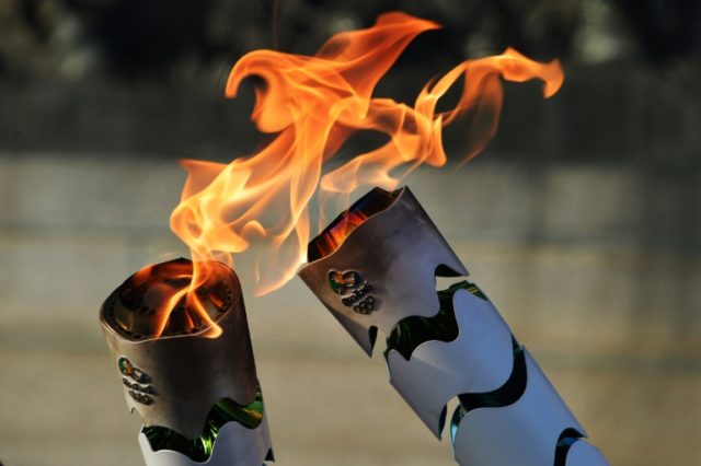 Brazilian residents pass the Olympic torch at Independence Park in Sao Paulo, Brazil on Ju