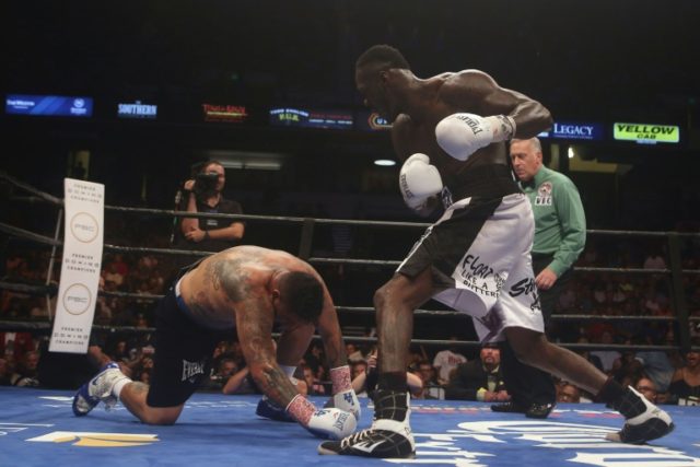Chris Arreola (L) is taken down by WBC World Heavyweight Champion Deontay Wilder during a