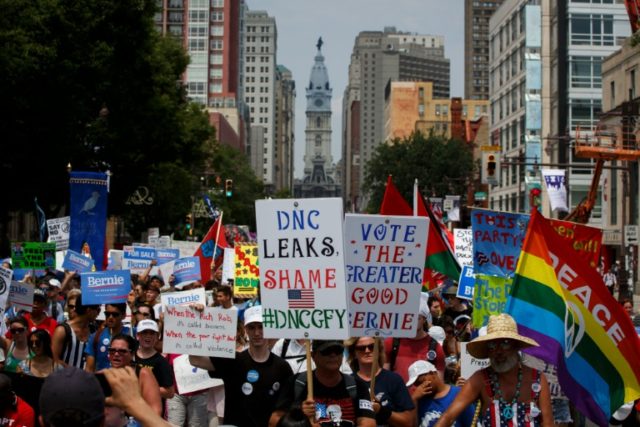 People hold signs in protest of the DNC email scandal at the 2016 Democratic National Conv