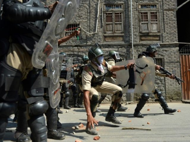 Indian police personnel prepare to throw stones towards Kashmiri protestors during clashes in Srinagar on July 1, 2016