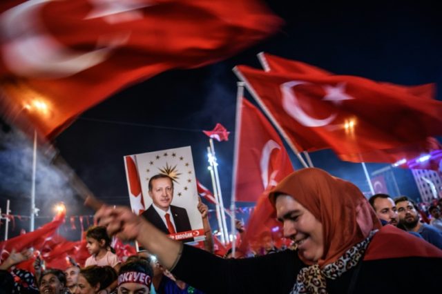 Supporters of President Erdogan hold Turkish national flags and a portrait of the presiden