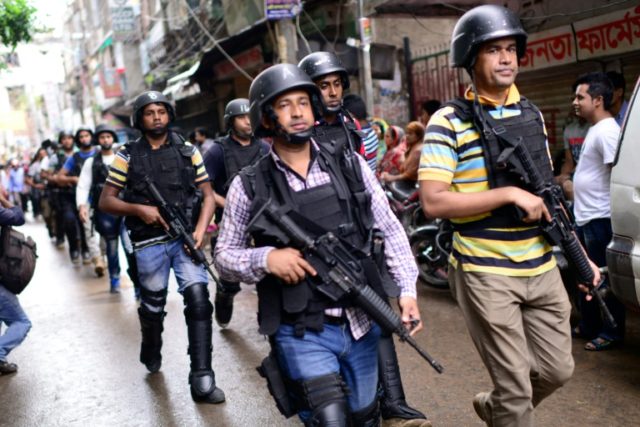 Bangladeshi police petrol the area near the house where police killed nine suspected Islam