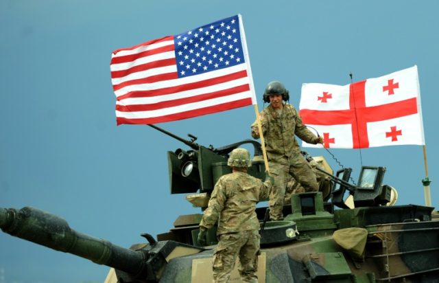 US servicemen stand atop a M1A2 Abrams tank during the Noble Partner 2016 joint military e