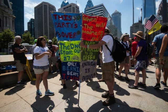 A supporter of former US Democratic presidential candidate Bernie Sanders holds banners in