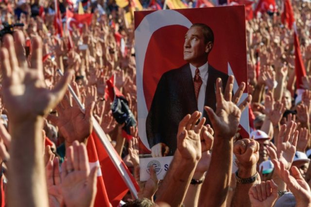Demonstrators rise their hands and hold a potrait picture of Mustafa Kemal Ataturk, founde