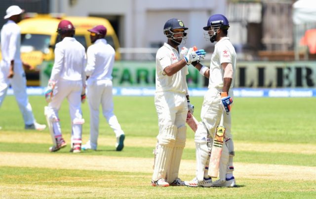 Lokesh Rahul of India celebrates with Cheteshwar Pujara after his century with a Six off W