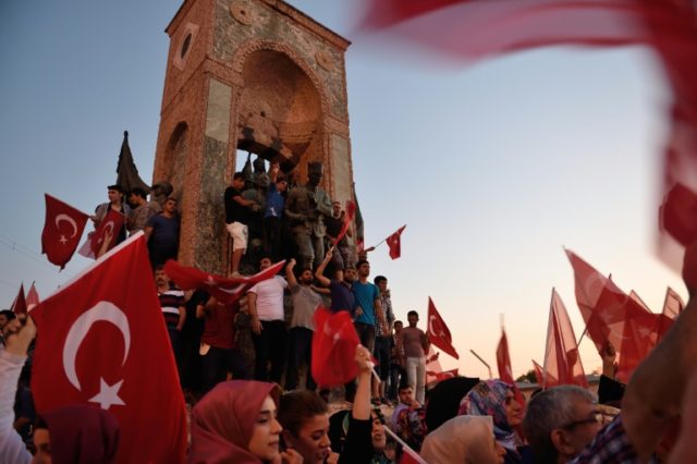 People wave Turkish flags next to a statue of the founder of modern Turkey Mustafa Kemal A