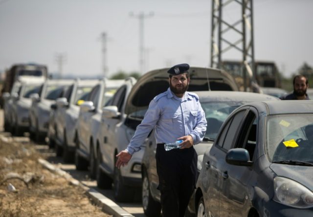 A Palestinian Hamas security official inspects vehicles coming from Israel on July 14, 201