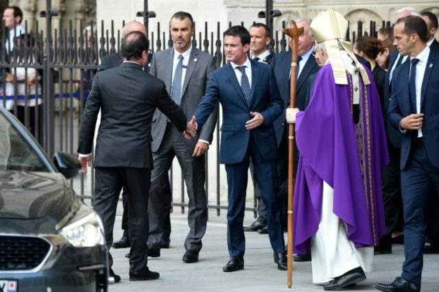 President Francois Hollande (L) shakes hands with Prime Minister Manuel Valls (C) after a