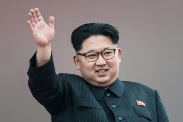 North Korean leader Kim Jong-Un waves from a balcony of the Grand People's Study House fol