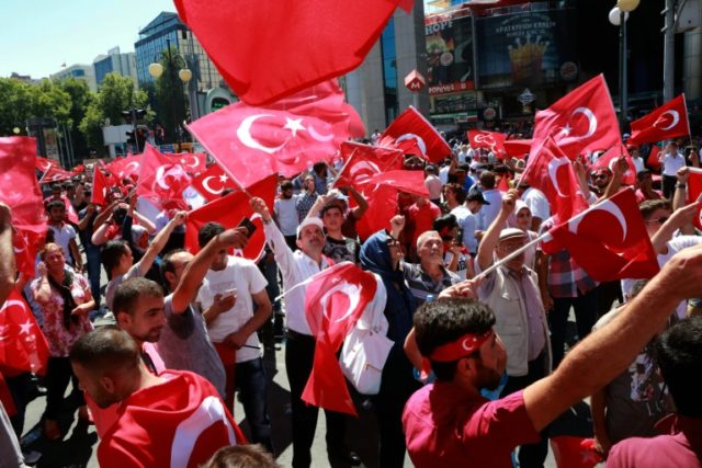 People wave national flags as they march from Kizilay Square to the Turkish General Staff