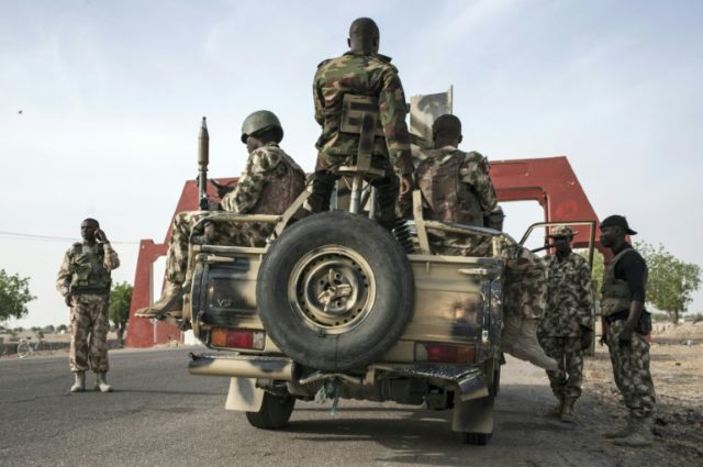 Nigerian Army soldiers prepare to leave Maiduguri in an armed convoy on the road to Damboa