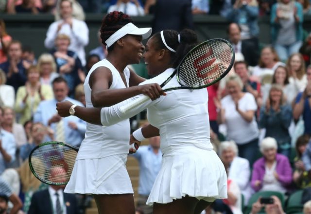 Serena Williams (R) embraces her sister Venus Williams as they celebrate beating Hungary's