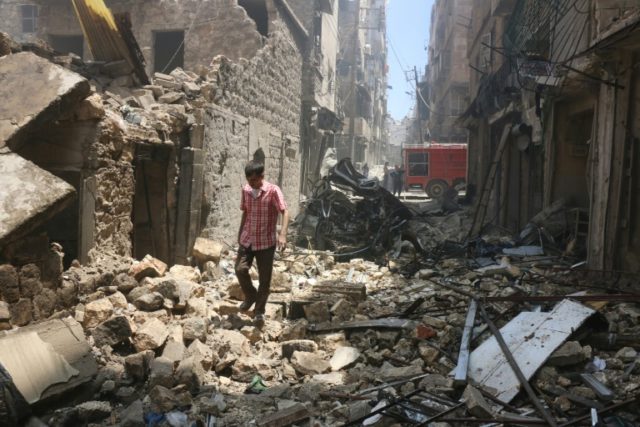 A man walks on the rubble of a destroyed building following reported air strikes by Syrian