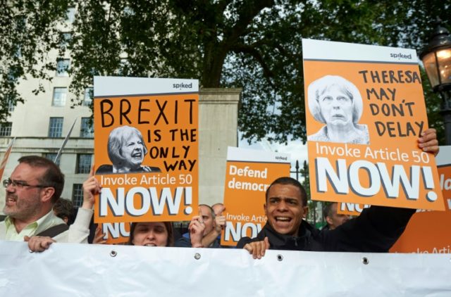Pro-Brexit supporters holds up placards as they demonstrate outside Downing street in cent