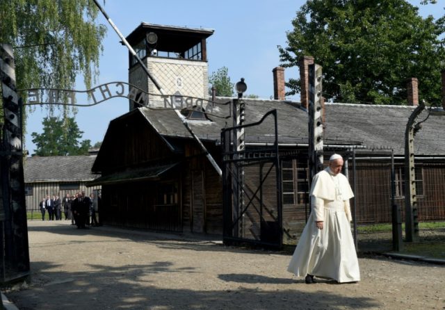 Pope Francis walks under the notorious "Arbeit Macht Frei" gate at the former Nazi death c
