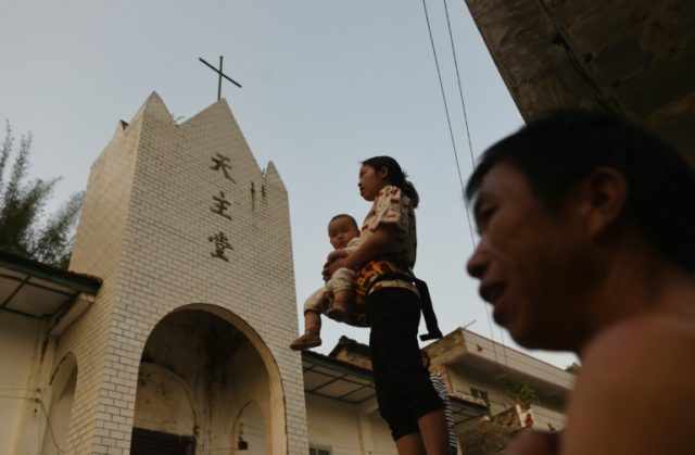 Villagers stand outside the Catholic church in Changjing, in China's southern Guangxi regi