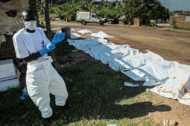 A South Sudanese ICRC (International Red Cross Committee) worker is seen next to body bags