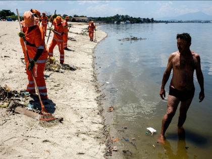 City cleaners collect floated debris on a beach at Guanabara bay in Rio de Janeiro, Brazil