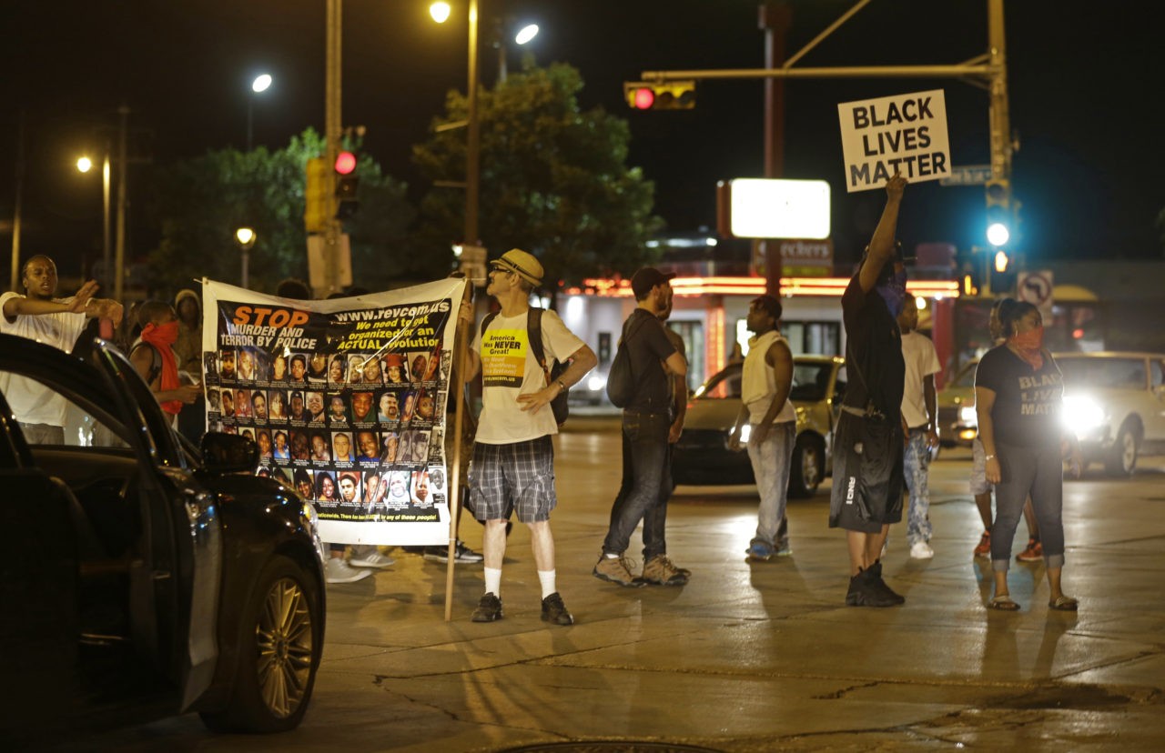 People protest and block traffic in Milwaukee, Sunday, Aug. 14, 2016.Police said one person was shot at a Milwaukee protest on Sunday evening and officers used an armored vehicle to retrieve the injured victim during a second night of unrest over the police shooting of a black man, but there was no repeat of widespread destruction of property. (AP Photo/Jeffrey Phelps)
