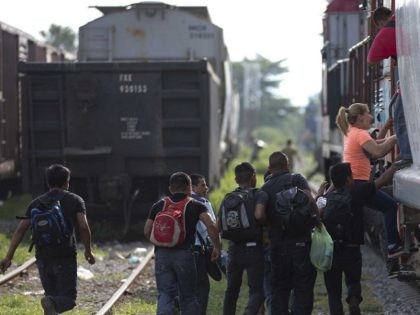 In this Saturday, July 12, 2014, photo, migrants run to jump on a train during their journey toward the U.S.-Mexico border, in Ixtepec, Mexico. The migrants pay thousands of dollars per person for the illegal journey across thousands of miles in the care of smuggling networks that in turn pay …
