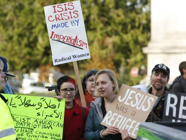 Supporters of refugees counter-protest an anti-refugee group gathered on the steps of the state capitol to protest Gov. Jay Inslee's welcoming of all refugees in Olympia, Washington on November 20, 2015. One week after terror struck in Paris, the attacks dominate the US political debate as President Barack Obama struggles …