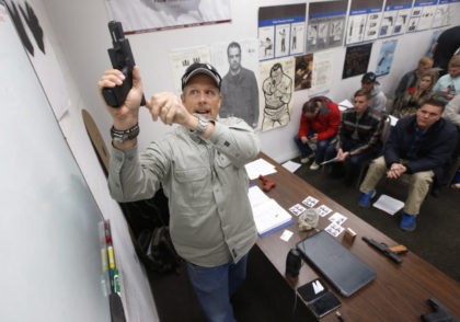 SPRINGVILLE, UT - JANUARY 9: Gun instructor Mike Stilwell, demonstrates an semi automatic hand gun as as he teaches a packed class to obtain the Utah concealed gun carry permit, at Range Master of Utah, on January 9, 2016 in Springville, Utah. Utahs permits, available for a fee to non-residents …