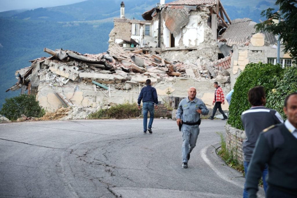 Victims and rescuers walk among the rubble of houses after a strong heartquake hit Amatrice on August 24, 2016. Central Italy was struck by a powerful, 6.2-magnitude earthquake in the early hours, which has killed at least three people and devastated dozens of mountain villages. Numerous buildings had collapsed in communities close to the epicenter of the quake near the town of Norcia in the region of Umbria, witnesses told Italian media, with an increase in the death toll highly likely. / AFP / FILIPPO MONTEFORTE (Photo credit should read FILIPPO MONTEFORTE/AFP/Getty Images)