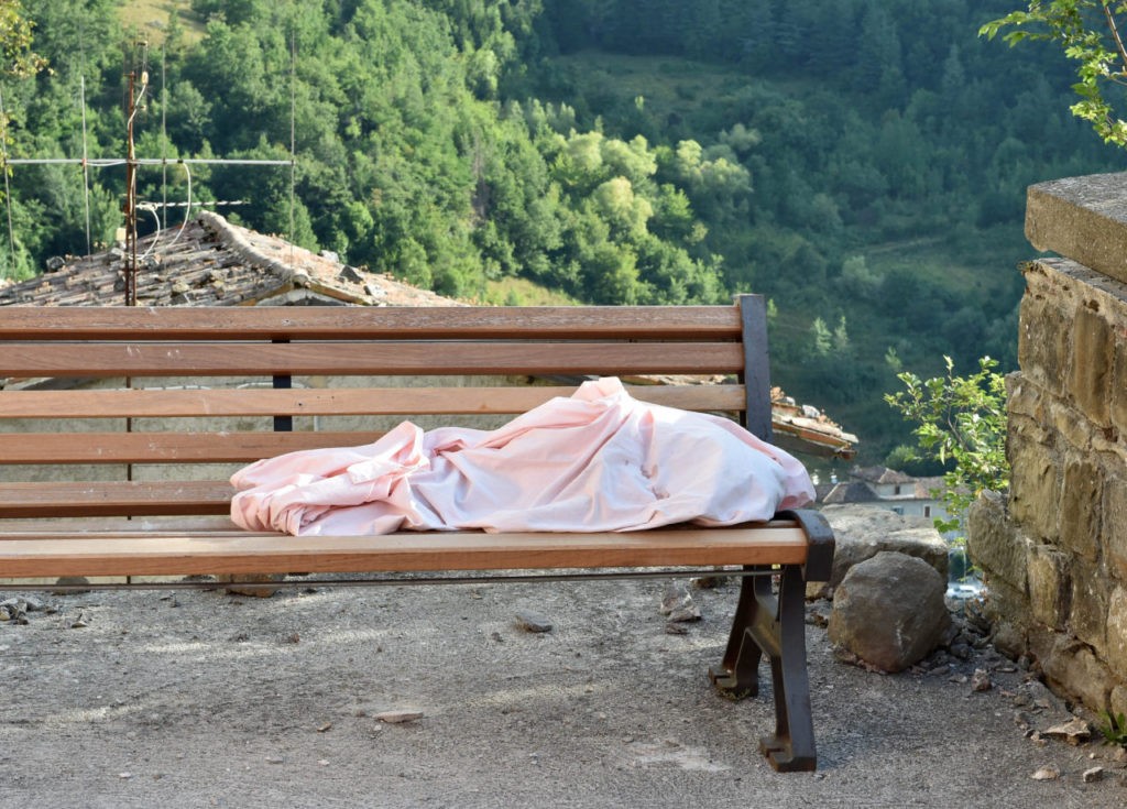 ARQUATA DEL TRONTO, ITALY - AUGUST 24: The body of an unidentifeid child lies on a bench on August 24, 2016 in Arquata del Tronto, Italy. Central Italy was struck by a powerful, 6.2-magnitude earthquake in the early hours, which has killed at least thirteen people and devastated dozens of mountain villages. Numerous buildings have collapsed in communities close to the epicenter of the quake near the town of Norcia in the region of Umbria, witnesses have told Italian media, with an increase in the death toll highly likely (Photo by Giuseppe Bellini/Getty Images)