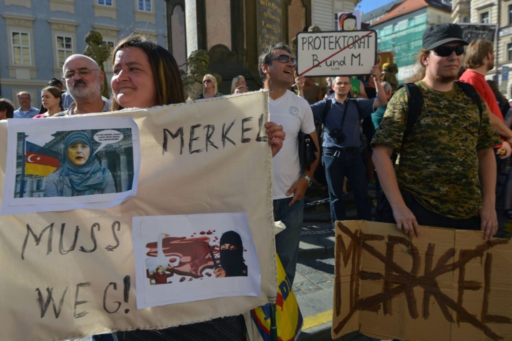 People hold banners against to protest against a visit of German Chancellor Angela Merkel in Czech Republic, on August 25, 2016 in Prague. / AFP / Michal Cizek (Photo credit should read MICHAL CIZEK/AFP/Getty Images)
