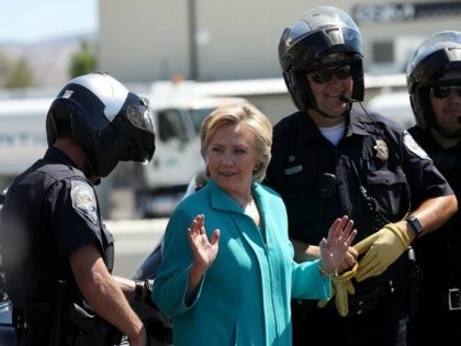 Democratic presidential nominee former Secretary of State Hillary Clinton talks with Reno police officers before getting onto her plane at Reno Tahoe International Airport on August 25, 2016 in Reno, Nevada.