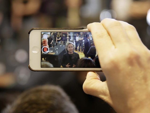 Hillary on iPhone (Charlie Niebergall / Associated Press)