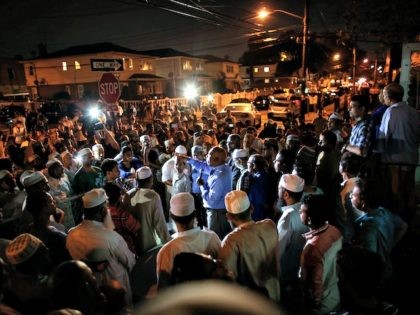 Community members pray outside the Al-Furqan Jame Mosque in Ozone Park after imam Maulama