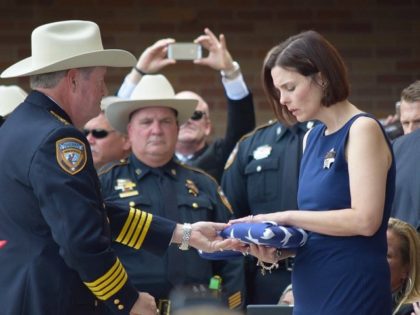The widow of Deputy Goforth receives the flag that draped her husband's casket from Sheriff Ron Hickman. (Photo: Breitbart Texaas/Bob Price)