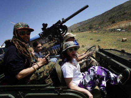 Gun fun: Danny Josephson, left, and his wife Jesse, right, ride in his father Kent Josephson's 1953 Willys Jeep with a Browning .30 calibre machine gun attached during the Big Sandy Shoot in Mohave County, Arizona