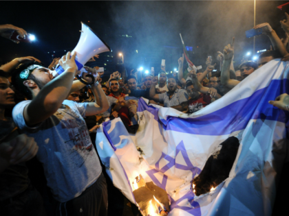 Turkish protestors set fire to Israel flag while they are shout slogans during a demonstra