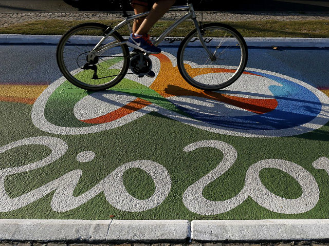 A woman rides her bicycle as she passes over a newly-painted bicyle lane ahead of the Rio