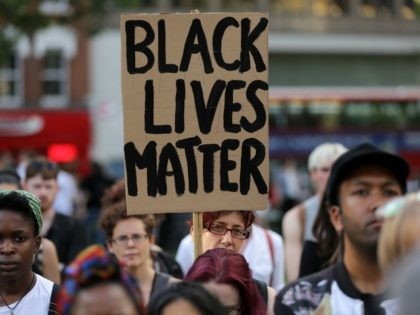 A woman holds up a placard in Altab Ali Park in east London, as she attends a Black Lives