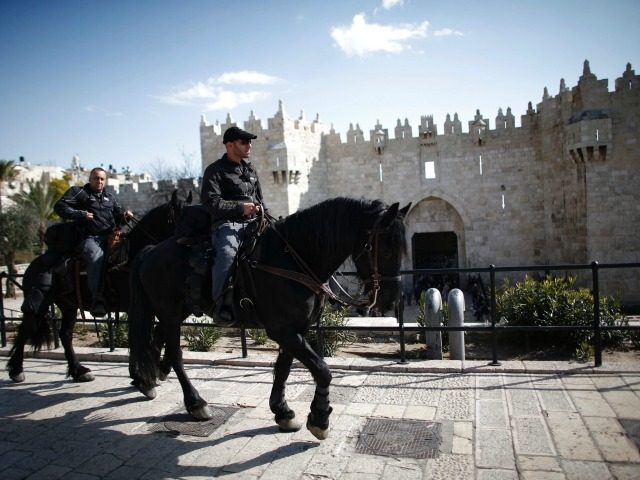 Two Israeli mounted police patrol the area around Damascus Gate outside of the Old City of