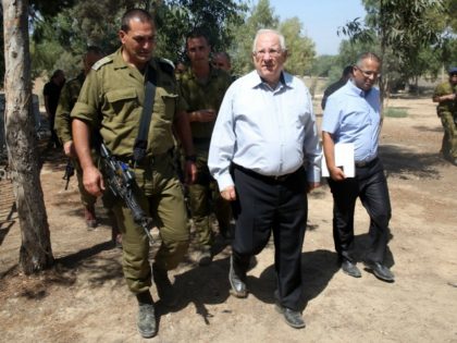 Israeli President Reuven Rivlin (C) is escorted by an army officer as he visits near the Israel-Gaza border area on August 23, 2016. During his visit Rivlin met with Israeli soldiers and was briefed on the security situation along the border. / AFP / MENAHEM KAHANA (Photo credit should read …