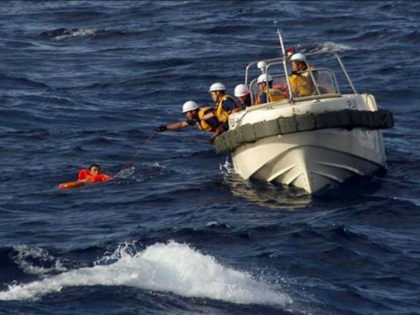 AT SEA : This handout picture taken on August 11, 2016 and released by the Japanese Coast Guard shows coast guards rescuing a crew member of a Chinese fishing boat near the waters of disputed East China Sea islands. Japan is searching for eight Chinese crew members who went missing …