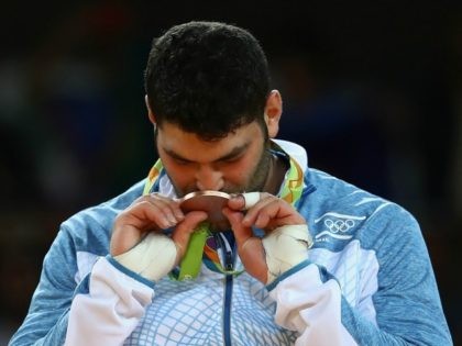 Bronze medalist Or Sasson of Israel kisses his medal on the podium during the Men's +