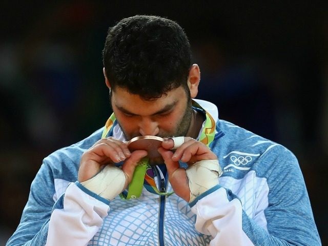 Bronze medalist Or Sasson of Israel kisses his medal on the podium during the Men's +