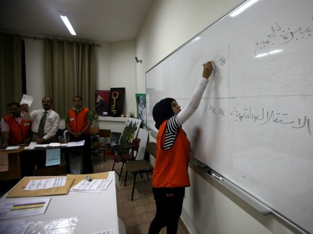 Palestinian poll officials tally the votes at a polling station in the West Bank city of R