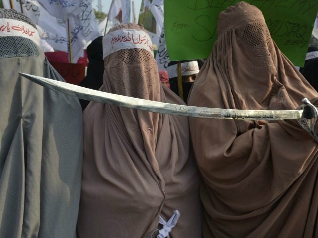 Pakistan women demonstrators wear burqas and hold a sword in protest against the printing