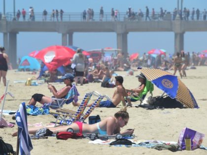 Beachgoers and sunbathers crowd Huntington Beach, California on July 22, 2016 during a southern California heatwave where temperatures topped 100 degrees in some areas as the National Weather Service issued an excessive heat warning for the valleys and mountains into the weekend. The weeklong 2016 Vans US Open of Surfing …