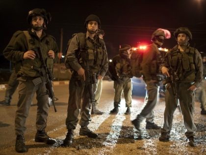 Israeli soldiers block the road in the Hawara checkpoint south of the West Bank city of Nablus on March 12,2011 after a Palestinian killed five Israelis in an overnight attack in the Jewish settlement of Itamar, in the Israeli-occupied occupied West Bank. According to media reports the vicitms were all …