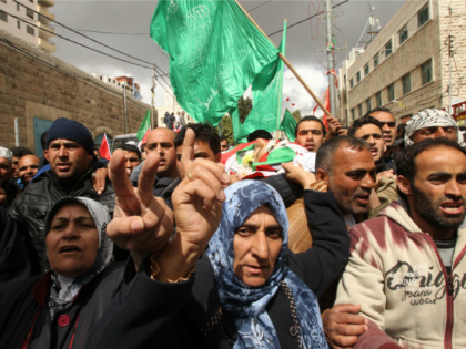 Mourners, including his mother (C), carry the body of Qassem Abu Ouda, a Palestinian who w